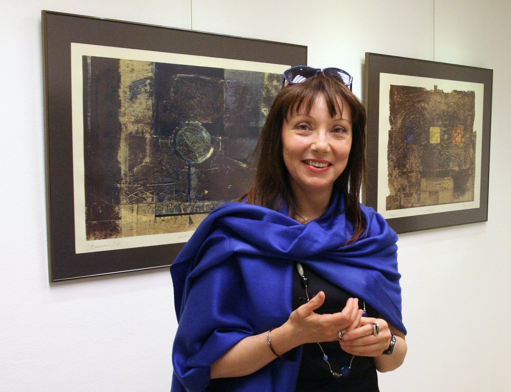 Desislava Deneva standing in front of framed artworks.